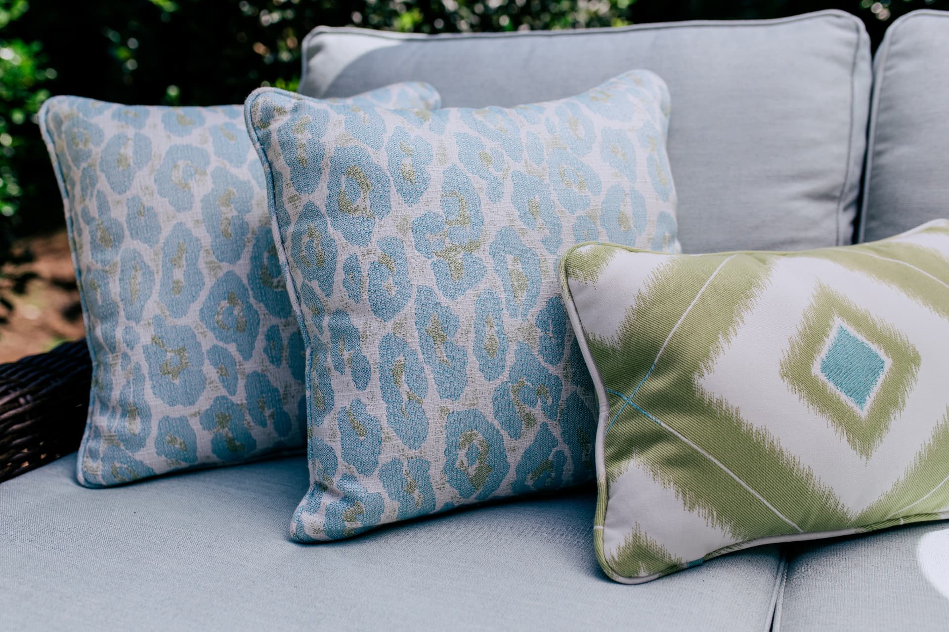 Close view of blue and green patterned outdoor pillows on a pale blue cushion · Great Falls, VA
